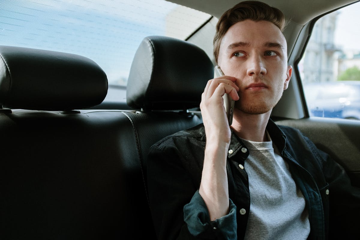 man talking on the phone inside a car